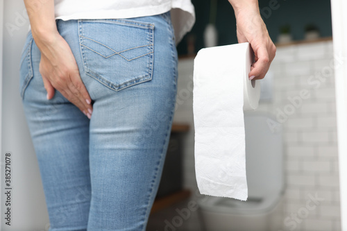 Obraz na plátně Woman holds hand on priest in other hand toilet paper and stands opposite the humiliated