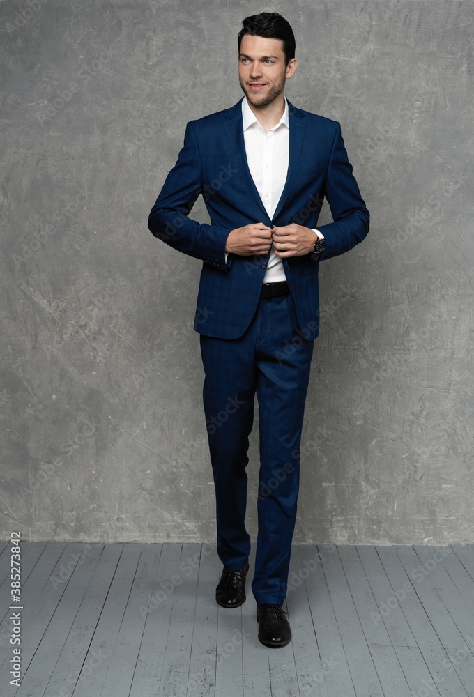 full length of handsome man wear blue suit isolated on grey background full length of handsome man wear blue suit isolated on grey background