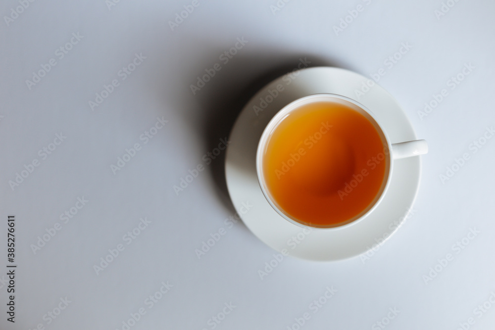 Top view of a cup of hot tea with copy space.Hot tea is in a white glass placed on a white background. There is space for the message. White background. Top view of a cup of hot tea with copy space.Hot tea is in a white glass placed on a white background. There is space for the message. White background.