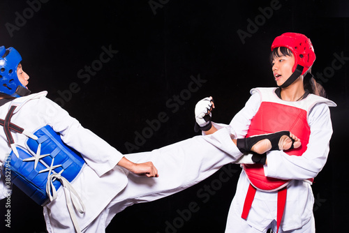 Two young asian athletes are taekwondo fighters and taekwondo Fight Wrestling on black background.