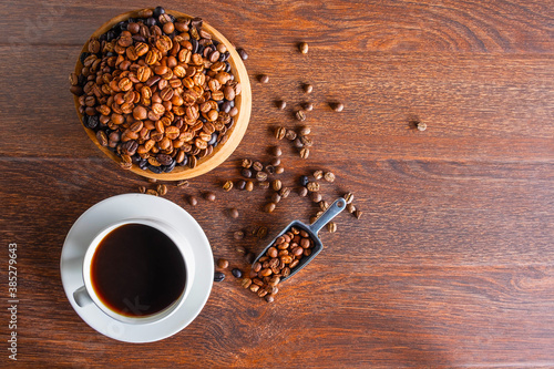 . black Coffee cups and coffee beans roasted on a wooden table