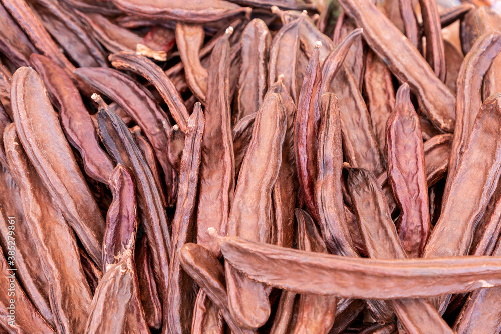 Carob pods (Ceratonia siliqua) on the marcet. Selective focus