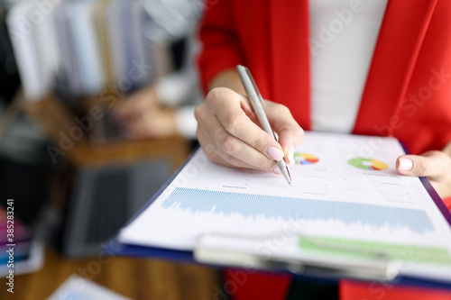 Business woman in red jacket holds clipboard with documents and pen closeup. Maintaining personnel documentation concept.