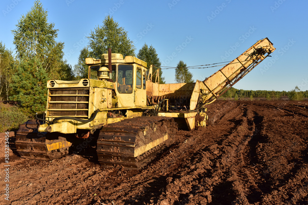 Root harvester for clear surface vegetation and cut through trees and stumps in the bog. Machinery for both clearing new peat production areas. Bog clearing machine