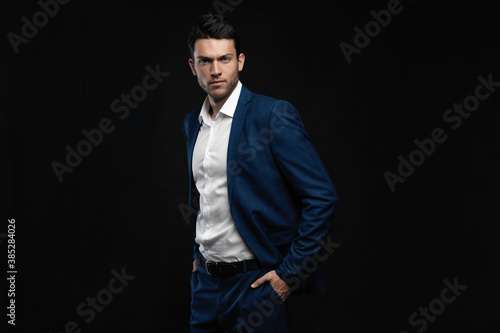 Handsome man wear blue suit isolated on black background