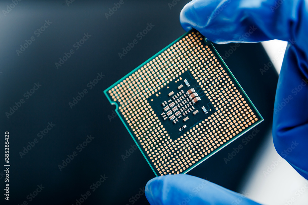 Close-up view on a new semiconductor microchip in gloved hand of computer scientist. Modern technology and hardware development