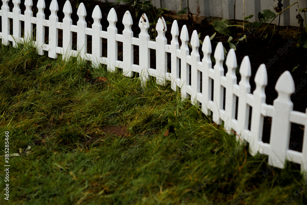 Plastic decorative small fence for a flower bed on a personal plot.