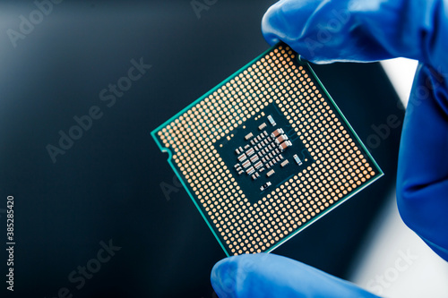 Obraz na płótnie Close-up view on a new semiconductor microchip in gloved hand of computer scientist. Modern technology and hardware development w salonie