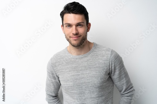 Handsome young man on white background looking at camera. Happy guy smiling. © opolja
