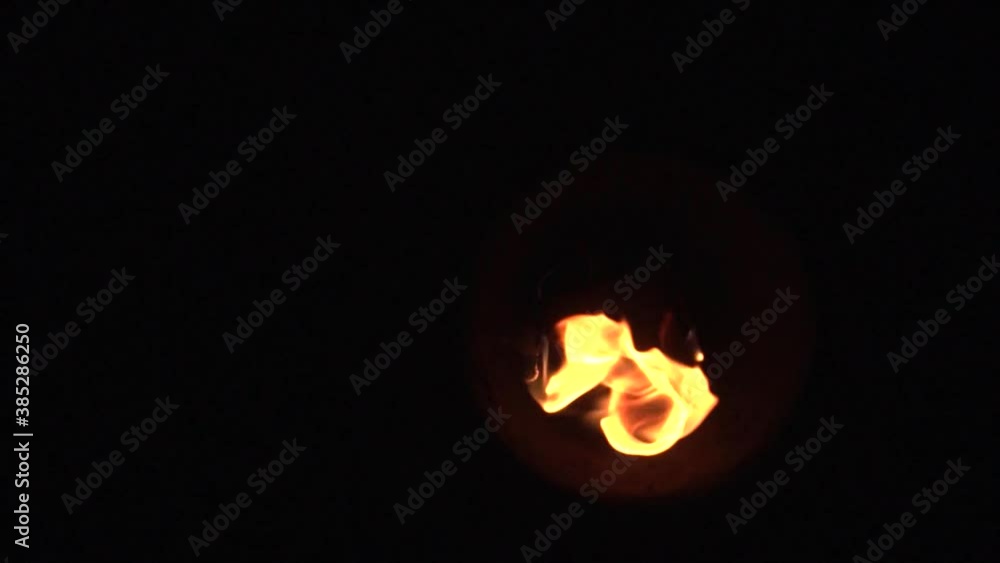 The fire burns on a torch wick on a black background, fire show. Slow motion The fire burns on a torch wick on a black background, fire show. Slow motion