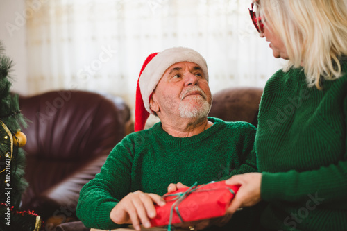 Senior woman giving Christmas present to hers husband