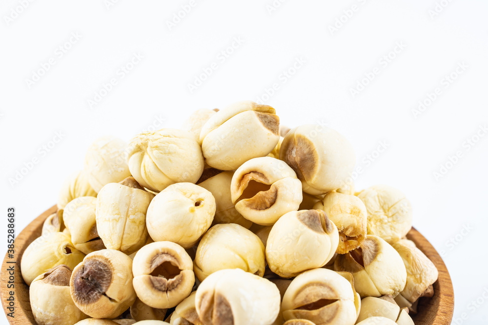 Dried white lotus seeds in a saucer on white background Dried white lotus seeds in a saucer on white background