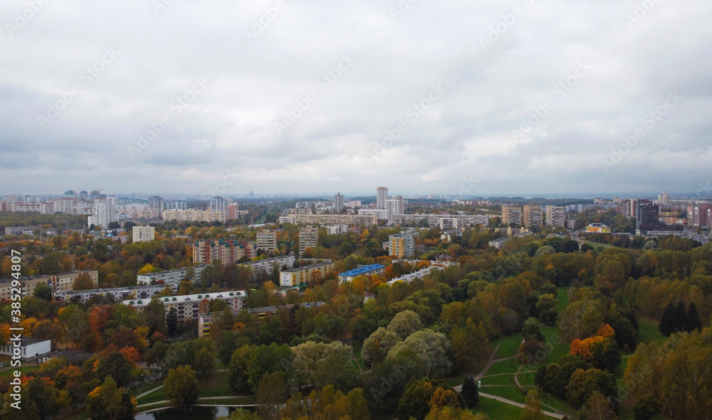 Top view of the autumn city near the park with trees