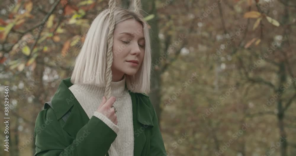 Thoughtful woman swinging in solitude under a big tree in autumn. slow motion Thoughtful woman swinging in solitude under a big tree in autumn. slow motion