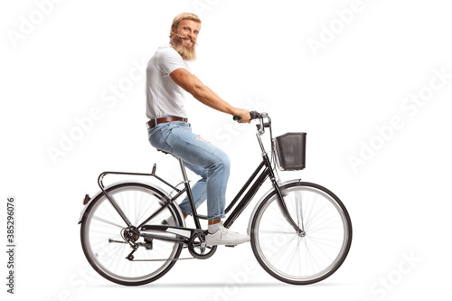 Bearded guy with moustaches riding a bicycle and smiling at camera