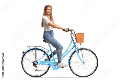 Young female with long hair riding a bicycle and smiling at camera