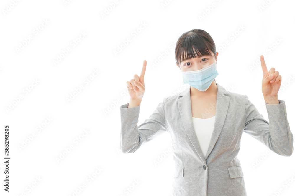 マスクをして指をさす若いビジネスパーソン