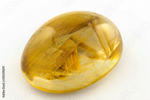 Quartz cabochon with golden rutilos inside photo