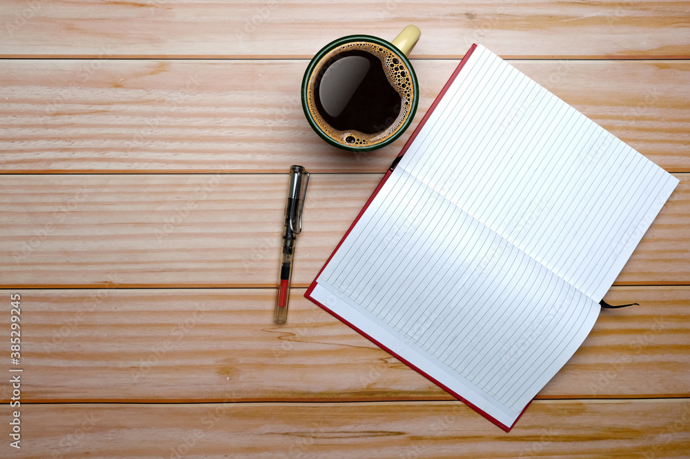 Relaxing day with great coffee And a notebook placed on a wooden table. selective focus, soft focus. Relaxing day with great coffee And a notebook placed on a wooden table. selective focus, soft focus.
