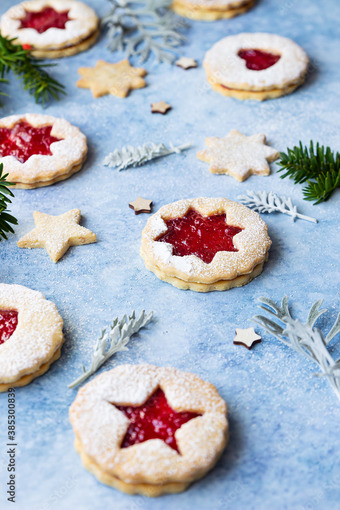 Linzer Christmas or New Year cookies filled with jam and dusted with sugar powder on blue background. Traditional Austrian Christmas cookies. Festive decoration.