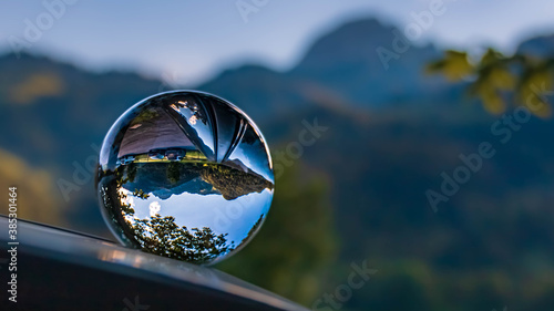 Crystal ball alpine landscape shot with reflections on a car roof at the famous Wendelstein, Bayrischzell, Bavaria, Germany © Martin Erdniss