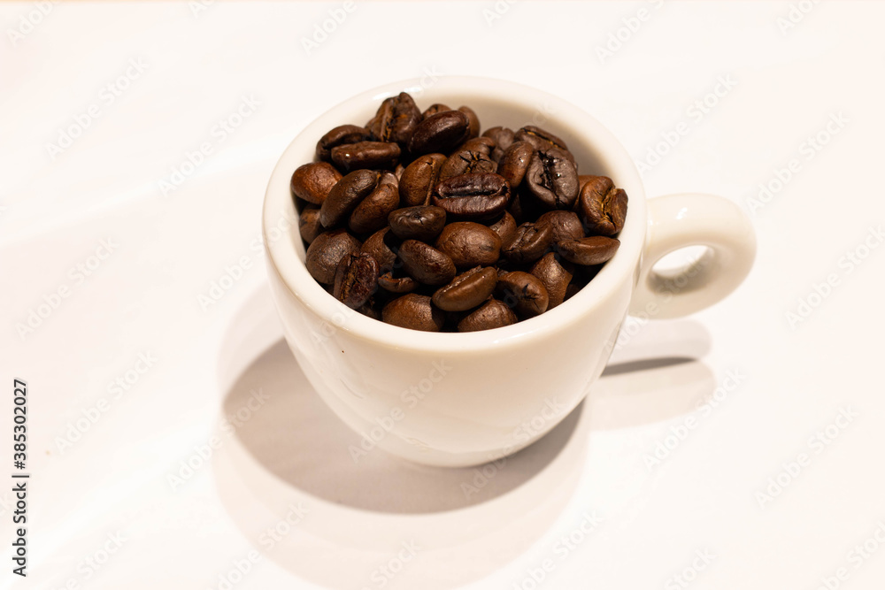Cup with roasted coffee beans on white background. Copy space Cup with roasted coffee beans on white background. Copy space