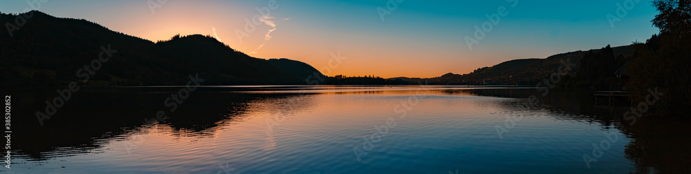 High resolution stitched panorama of a beautiful alpine sunset view with reflections at the famous Schliersee, Bavaria, Germany