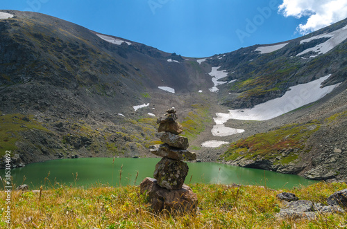 Tower of stones on the shore of a mountain lake