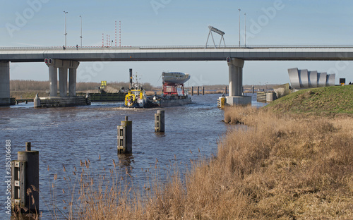 Transport of a super sailing yacht on pontoon with towing boats. River. Zwartewater. Noordoostpolder Ramspol.  photo