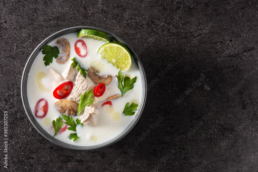 Traditional Thai food Tom Kha Gai in bowl on black background. Top view.Copy space Traditional Thai food Tom Kha Gai in bowl on black background. Top view.Copy space