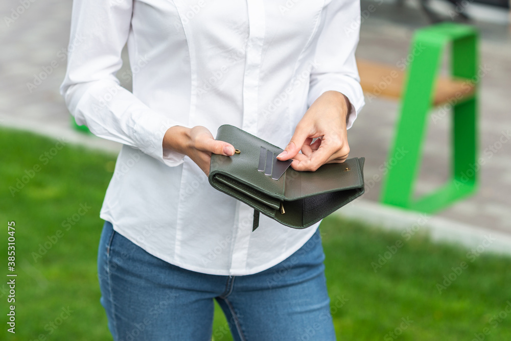 Girl in white holds an open wallet in her hand Girl in white holds an open wallet in her hand
