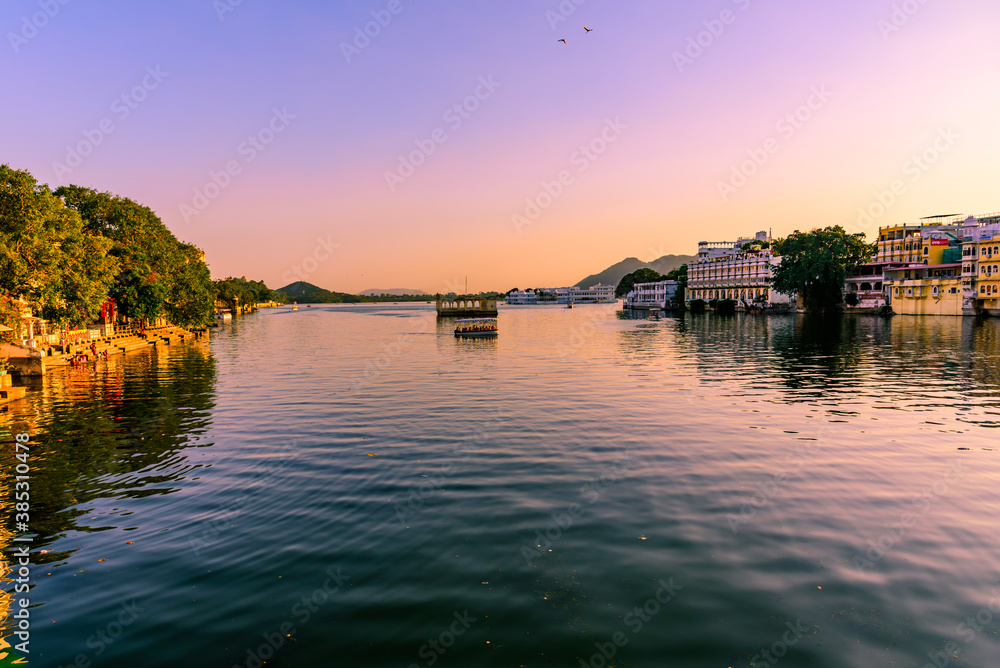 Panoramic sunset view of Udaipur city at Lake Pichola from Ambrai Ghat which is famous tourist vacation destination in Rajasthan, India.