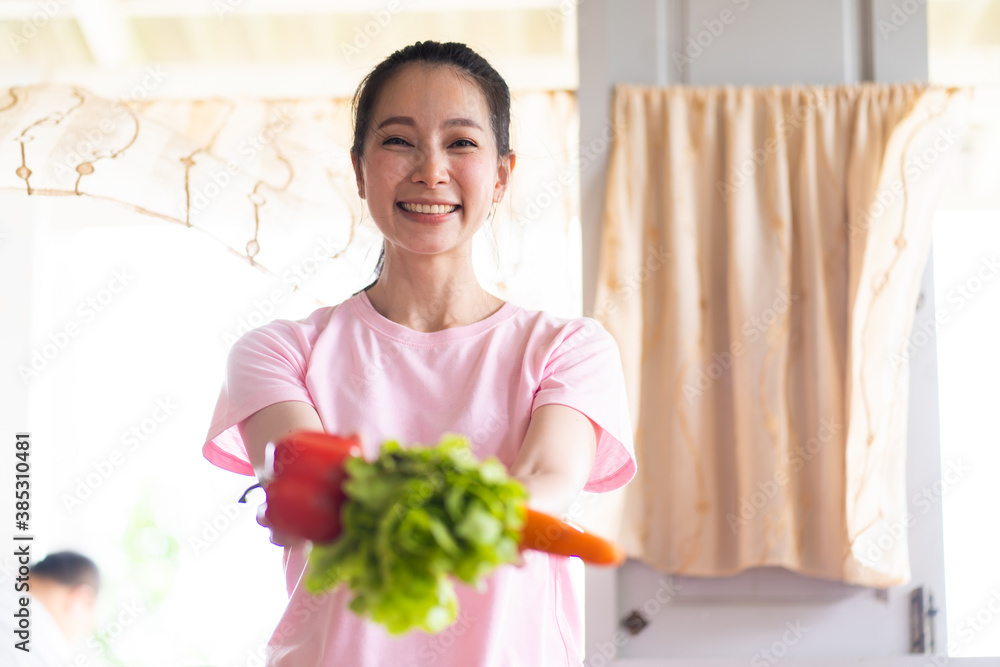 Young Asian Woman with fresh vegetables in her hands. Healthy Lifestyle and Cooking At Home Young Asian Woman with fresh vegetables in her hands. Healthy Lifestyle and Cooking At Home