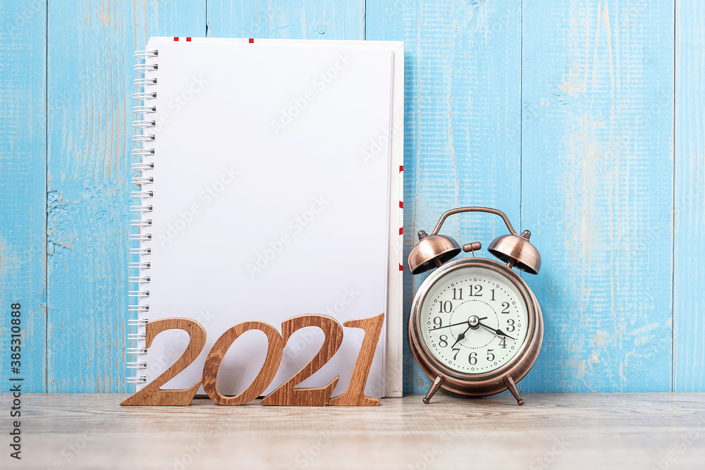 2021 Happy New Year with blank notebook, retro alarm clock and wooden number. New Start, Resolution, Goals, Plan, Action and Mission Concept 2021 Happy New Year with blank notebook, retro alarm clock and wooden number. New Start, Resolution, Goals, Plan, Action and Mission Concept