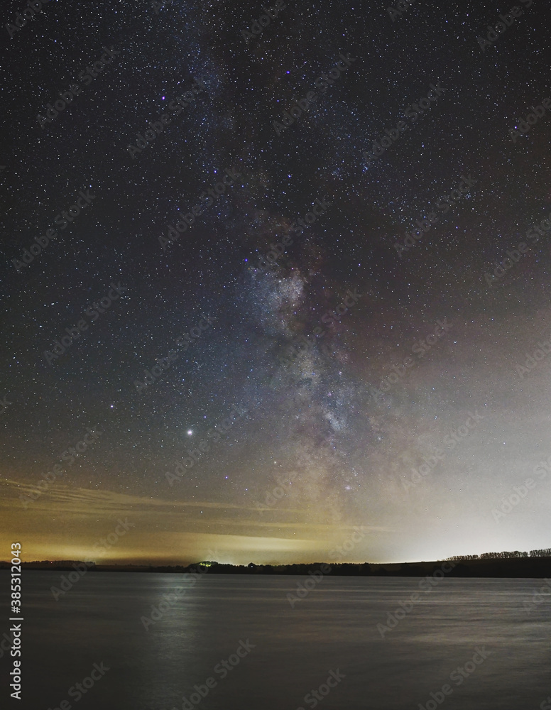 Night landscape. Lake on the background of the starry sky and the milky way.