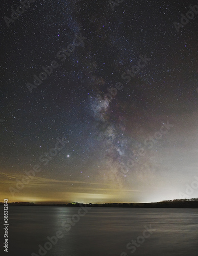Night landscape. Lake on the background of the starry sky and the milky way.