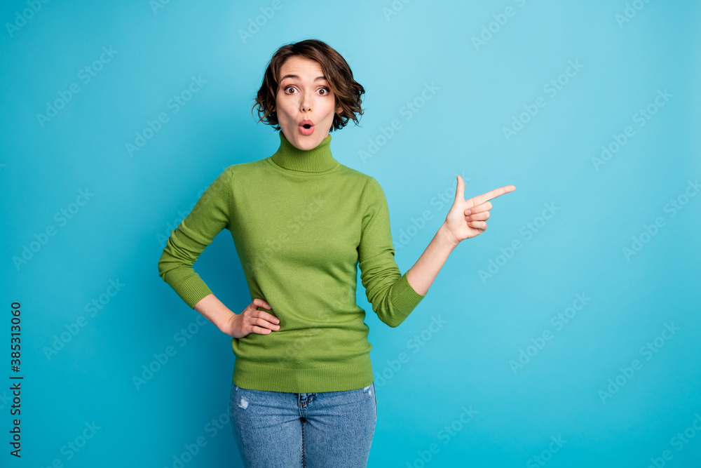 Portrait of astonished girl promoter point index finger copyspace direct way unbelievable ads promotion wear good look jumper isolated over blue color background Portrait of astonished girl promoter point index finger copyspace direct way unbelievable ads promotion wear good look jumper isolated over blue color background
