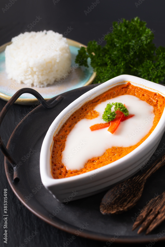 Asian food concept Thai Steamed Curried Fish, Steamed Red Curry Custard Hor Mok in white ceramic boat shape on rustic iron tray on black background Asian food concept Thai Steamed Curried Fish, Steamed Red Curry Custard Hor Mok in white ceramic boat shape on rustic iron tray on black background