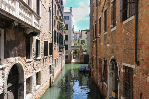Beautiful quiet small canal ,with a boat, in Venice . Beautiful and romantic travel destination concept.