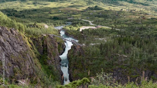 A aerial view of the newly built bridge above the magnificent Voringsfossen waterfall in Hardangervidda national park, Norway. A powerfull torrent of water rushing under the bridge. photo