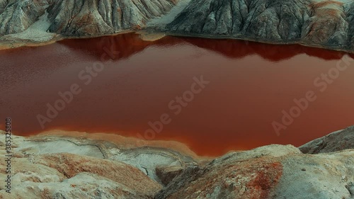 Red lake in beautiful mountains. Martian landscape. Fantastic quarry. The video can be used in movies, reportage, as footage, in a music video.