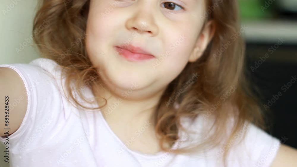 Baby girl eating sausage barbecue. Caucasian child eats food. Emotional child eats healthy food appetizing. Portrait of a kid for a meal Baby girl eating sausage barbecue. Caucasian child eats food. Emotional child eats healthy food appetizing. Portrait of a kid for a meal