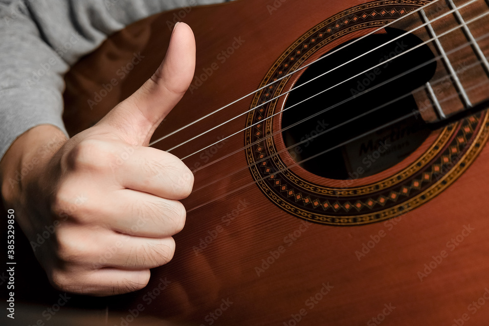 Fototapeta premium man playing acoustic guitar thumbs up