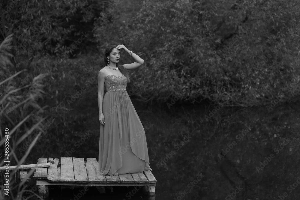 Woman standing near the lake in black and white