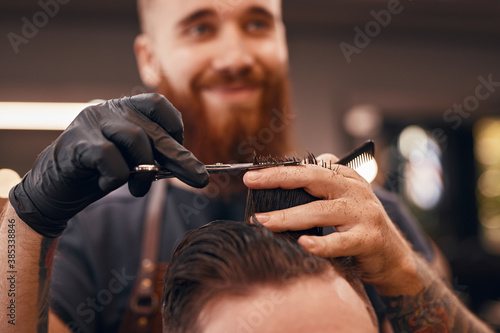 Blurred barber cutting hair of client