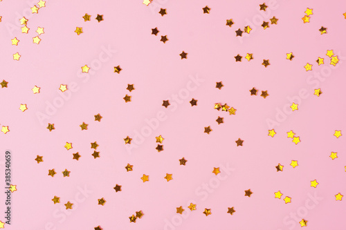 Golden confetti on pink. Colorful Christmas or holiday background