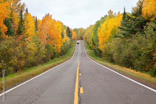 Highway in northern Minnesota lined with trees in autumn color