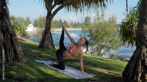 Slim Woman Doing Tiger Pose (Vyaghrasana) To Child’s Pose (Balasana) On A Mat - Yoga At The Beach - Burleigh Heads Beach In Queensland, Australia. - wide shot photo