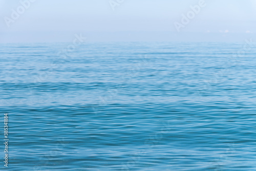 Morning sea surface with calm waves and haze on the horizon. Sea background