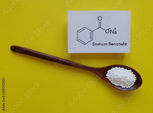 Structural chemical formula of sodium benzoate molecule with white sodium benzoate preservative. Sodium benzoate is a widely used preservative in many foods, cold drinks, cosmetics. Food additive E211 photo